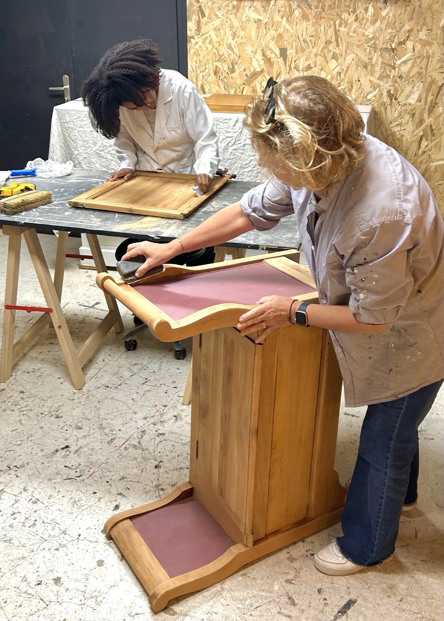 Femmes en train de poncer un meuble en bois