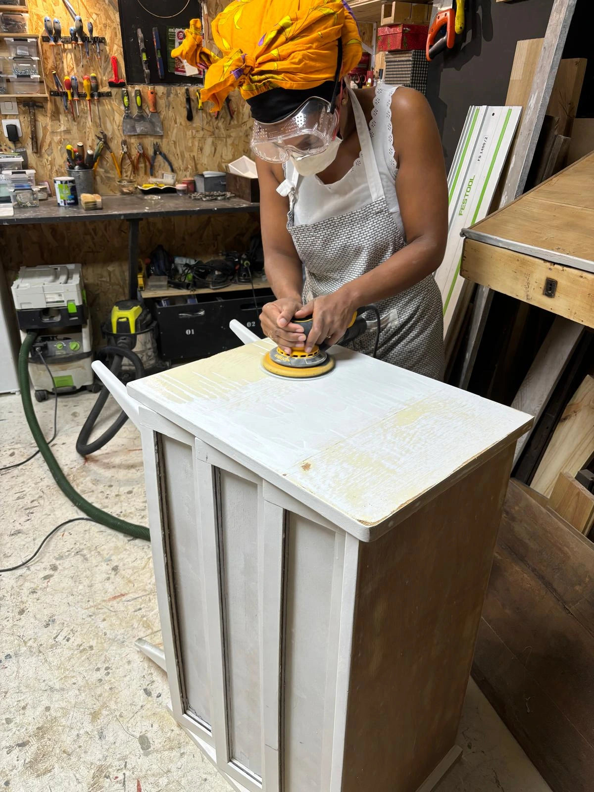 Femme en train de poncer meuble en bois